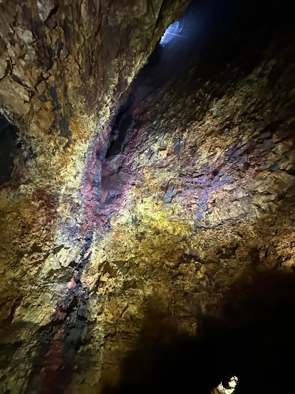 A dark overhang above a wall of pale yellow rock