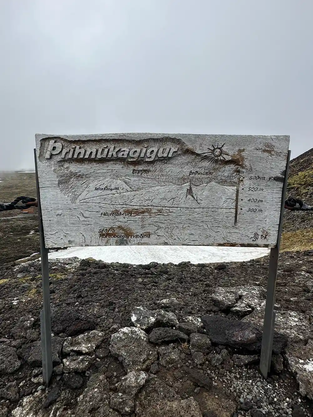 The Thrihnukagigur sign standing on bare lava in cloud
