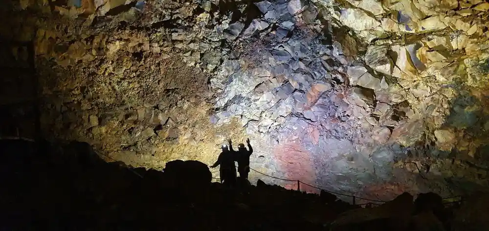 Two visitors casting shadows on the lit chamber wall