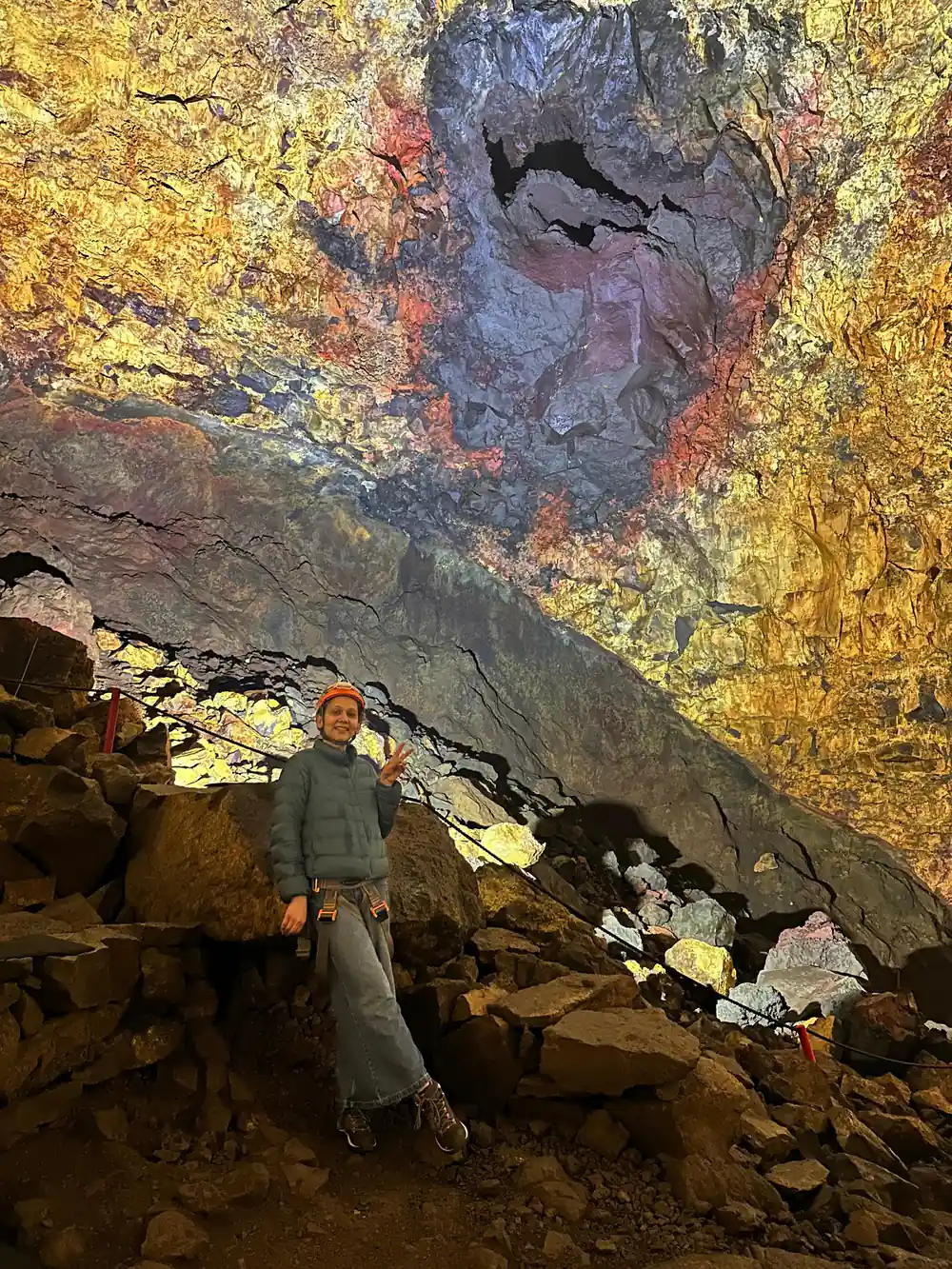 A visitor standing on the rubble under the lit chamber wall