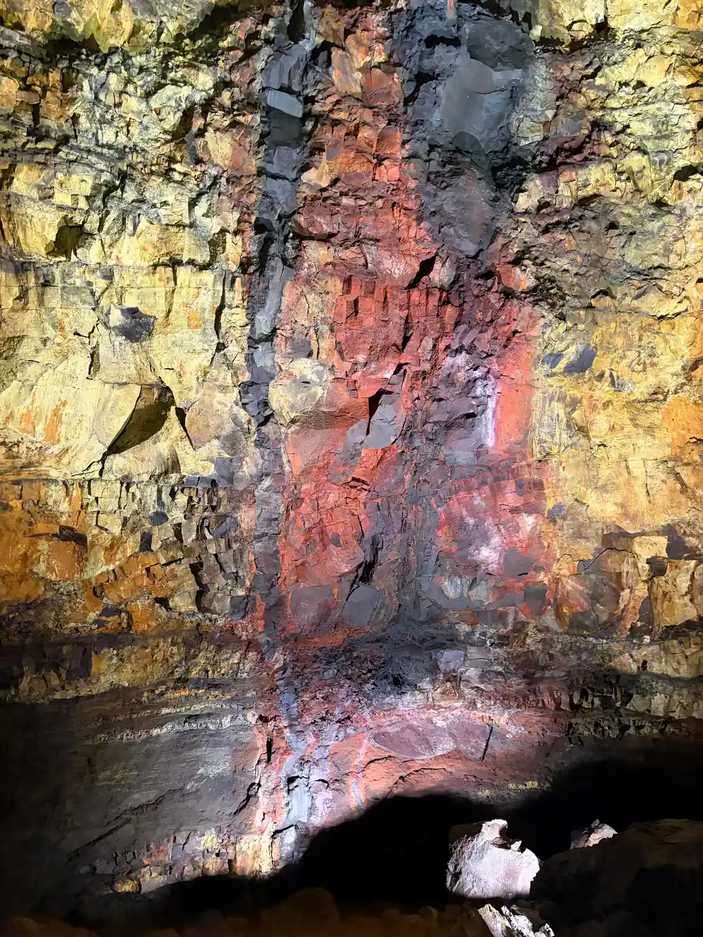 A vivid red vertical streak on gold rock